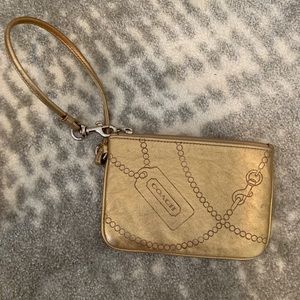 Gold coach wristlet used